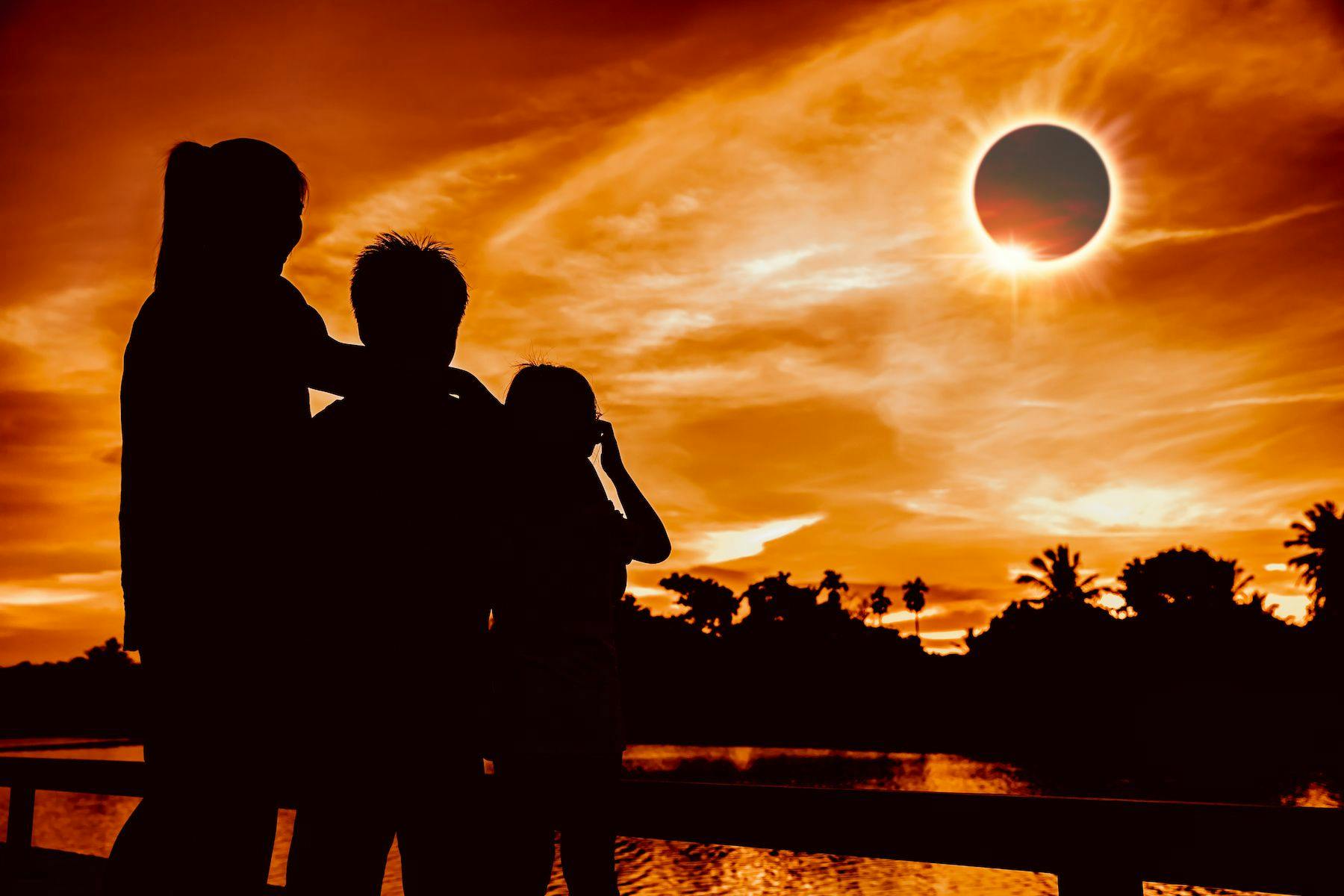 Family safely viewing a total solar eclipse | image credit: kdshutterman / stock.adobe.com