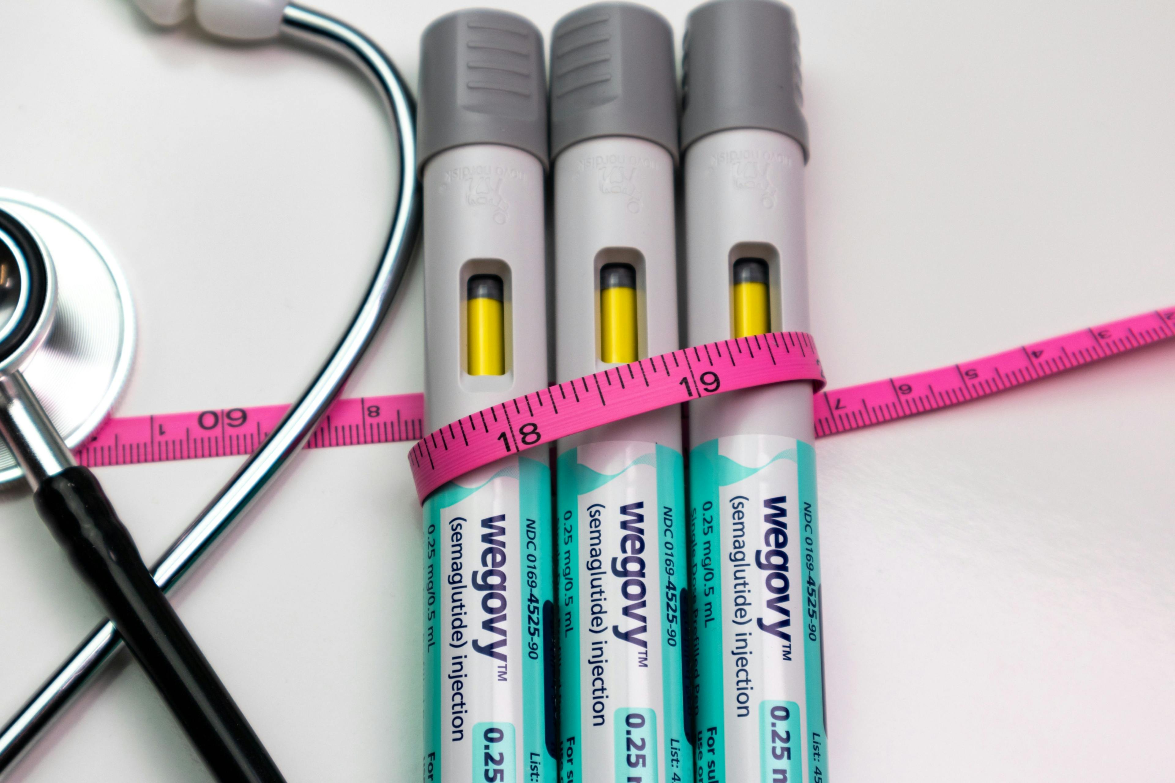 Wegovy pens with pink tape measure and stethoscope / K KStock - stock.adobe.com