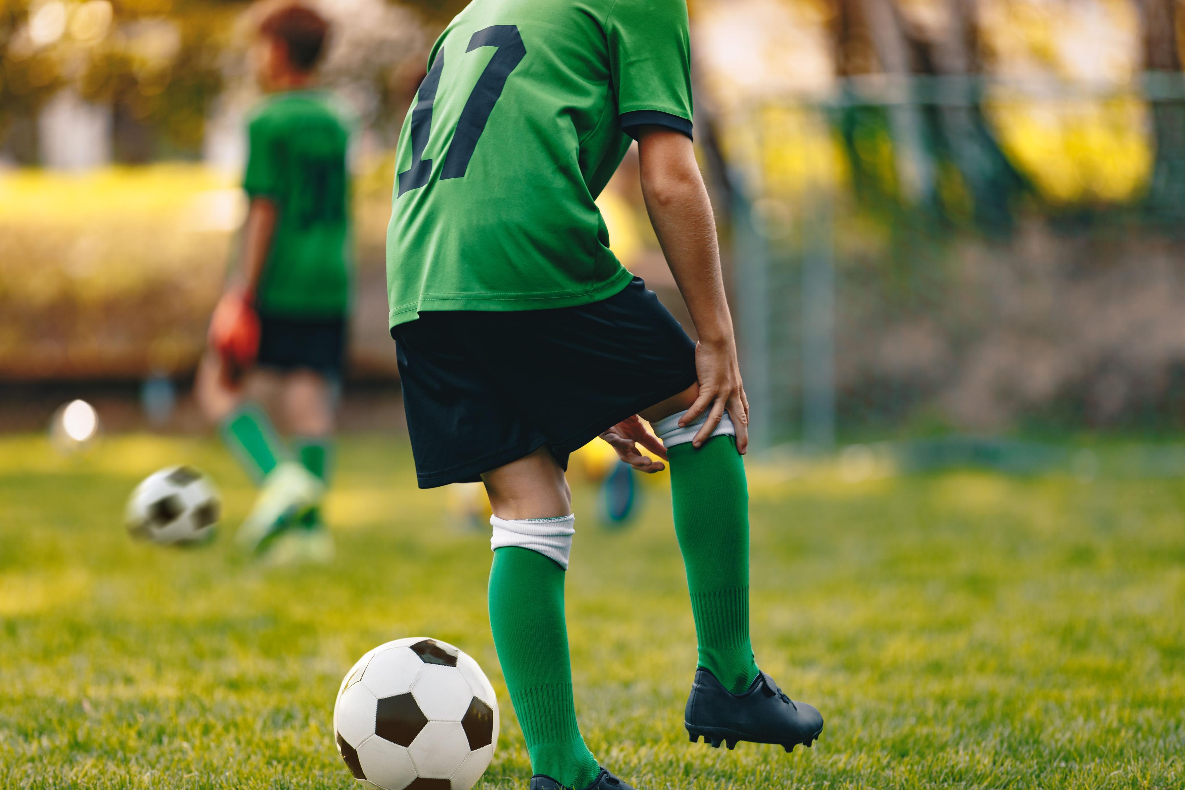 Young soccer player holding injured knee / matimix - stock.adobe.com